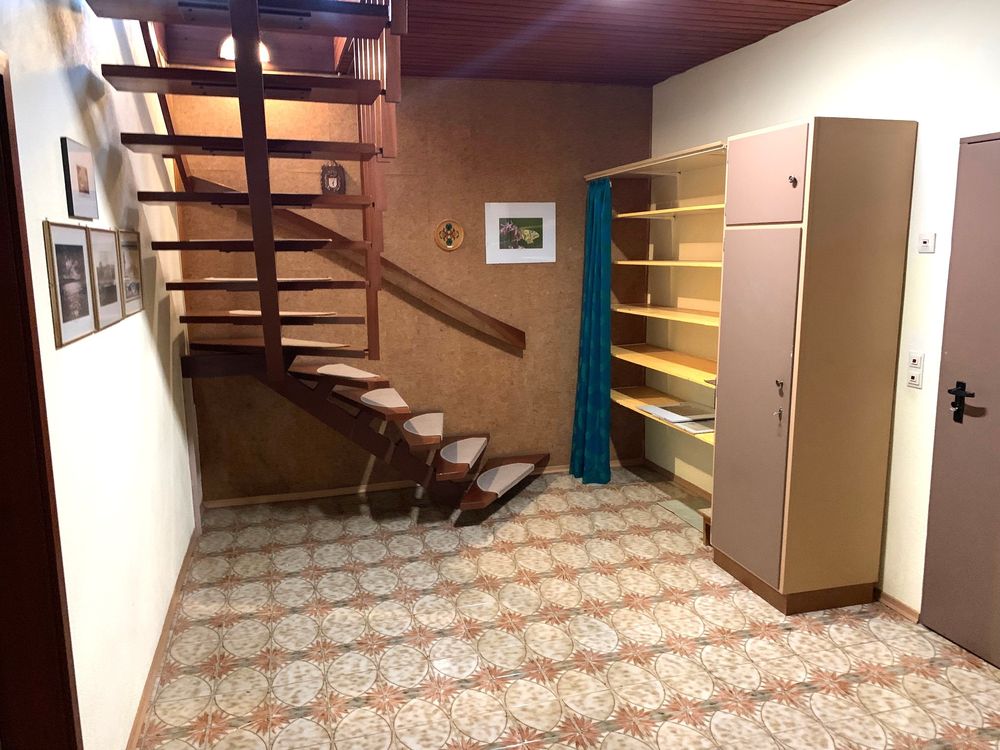 Treppe vorher: dunkle Holztreppe, Holzvertäfelung, gemusterter Boden